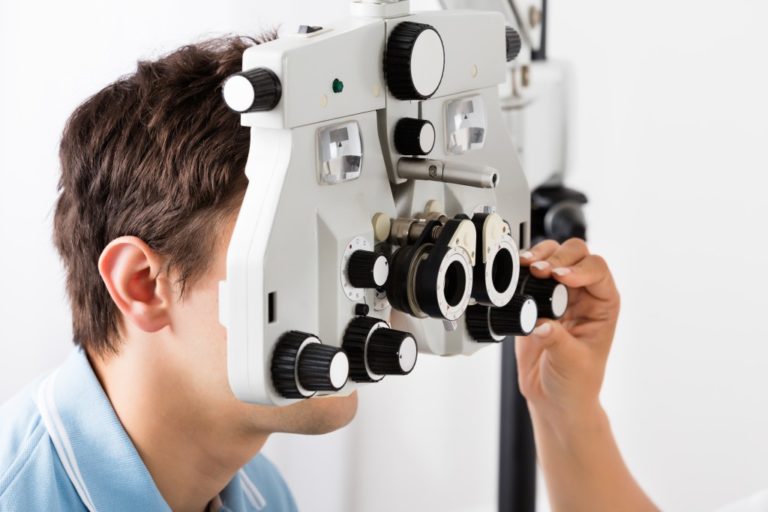 man geeting his eyes check through an optical machine