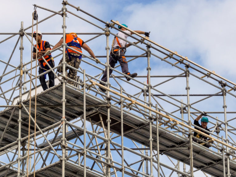 workers on top of a scaffolding