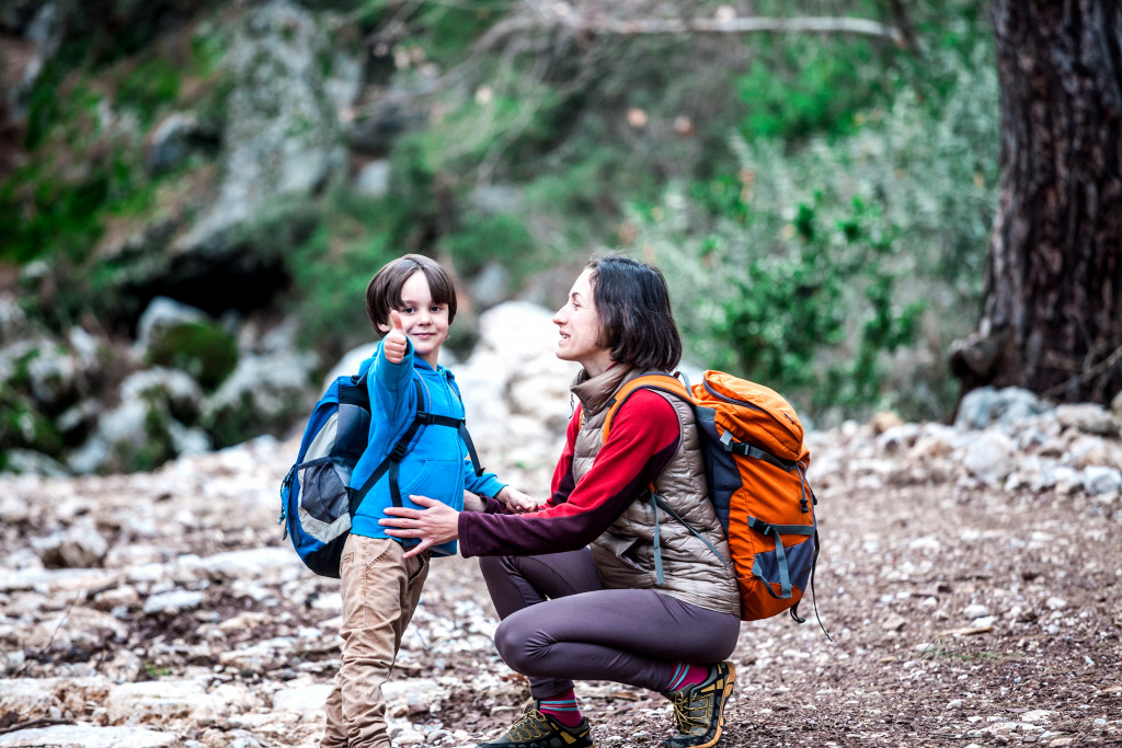 mother and son trekking in the woods